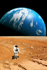 Wall Mural - a stranded astronaut surveys his situation on a barren moon - elements of this image furnished by na