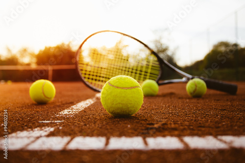 Cuadros en Lienzo Pelotas de tenis con la raqueta en la cancha de arcilla