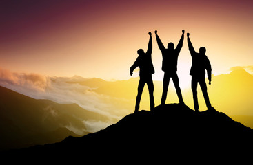Wall Mural - silhouettes of team on mountain peak. sport and active life concept