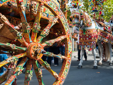 close up view of a colorful wheel of a typical sicilian cart during a folkloristic show