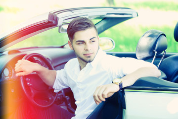 Pretty young man in cabriolet, outdoors