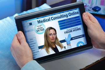 hands of a man at a website of online health service in the tablet / man searching web internet for recruitment health insurance on internet with tablet in you home