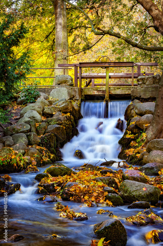 Naklejka na szybę Waterfall in the forest on autumn scenery. Oliwa, Poland.