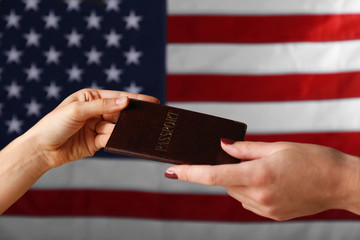 Wall Mural - One hand giving the passport to another on American Flag background