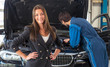 Smiling woman in a car servicing garage