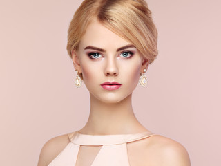 Portrait of beautiful sensual woman with elegant hairstyle.  Perfect makeup. Blonde girl. Fashion photo. Jewelry and dress