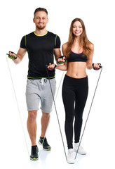 Happy athletic couple - man and woman with with ropes on the whi