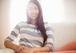 © WavebreakmediaMicro - Smiling asian woman on couch