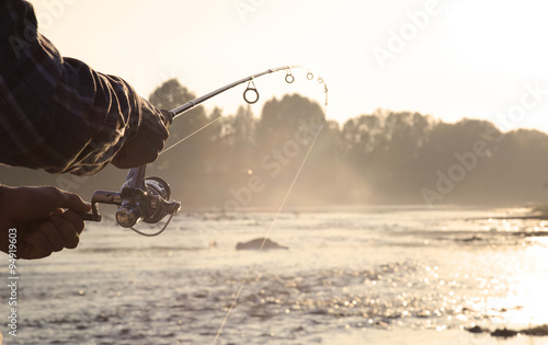 Cuadros en Lienzo the fisherman is fishing on a river in the early morning.