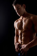 © fotofabrika - Strong athletic man on black background
