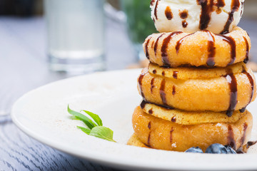 delicious dessert donuts with apples and ice cream on a white plate with decoration on a wooden table in a restaurant