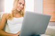 © WavebreakMediaMicro - Pretty blonde using laptop on couch