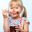 © karelnoppe - Cute girl eating chocolate yogurt.