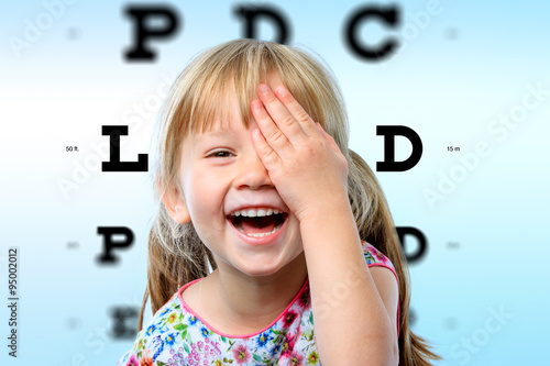 Cuadros en Lienzo Girl having fun at vision test.