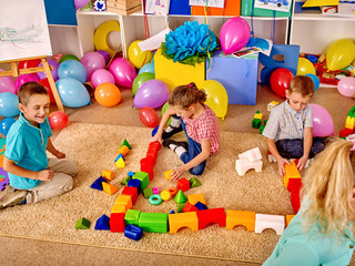 Group children game blocks on carpet floor .