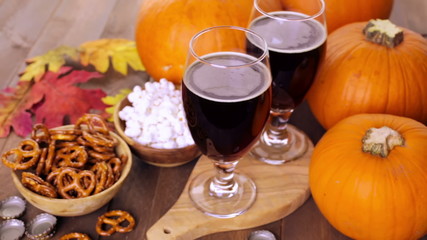 Wall Mural - Craft pumpkin beer in beer glasses with salty pretzels and popcorn