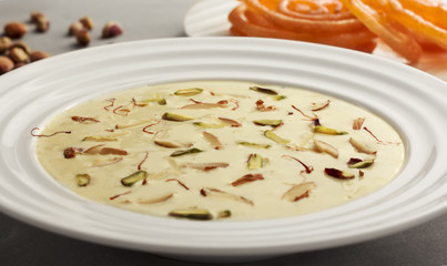 Delicious Indian sweet Rabdi made of condensed milk topped with almonds, pistachio and saffron which is accompanied with hot Jalebi.