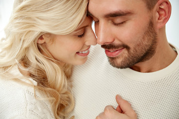 Wall Mural - close up of happy couple faces with closed eyes