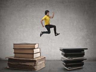 Man jumping from a pile of book to another