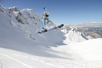 Flying snowboarder on mountains