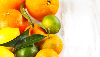 Sticker - Fresh citrus fruits with leaves on wooden background