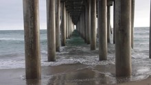 Huntington Beach Pier Underneath With Waves / Huntington Beach Pier Underneath With Waves Crashing Among The Cement Pier Pylons  Royalty Free Stock Photo