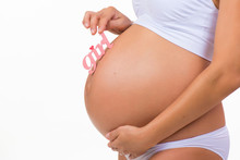 Close-up Of Pregnant Tummy With Pink Label "Girl" For Newborn Daughter On  Horizontal White Background