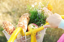 Young Woman Driving Bike With Basket Of Fresh Foodstuffs, Close-up