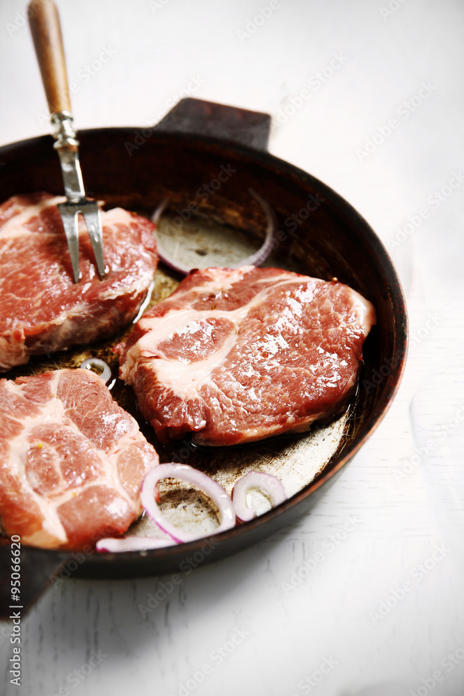 Marbled beef steak on pan and spices on color wooden background
