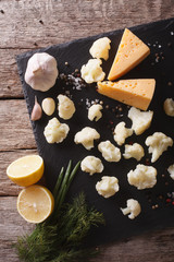 Wall Mural - Preparation of cauliflower with cheese on board. vertical top view
