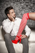 © sakkmesterke - Woman in sexy christmas outfit seduce man on sofa