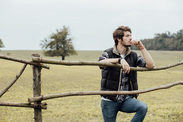 young man next to a wooden fence