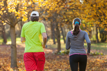 Wall Mural - Young couple running in autumn season