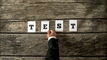 male hand assembling the word test