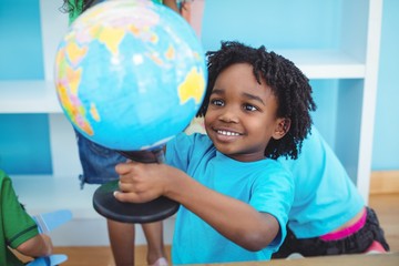 Wall Mural - Small boy holding a globe of the world