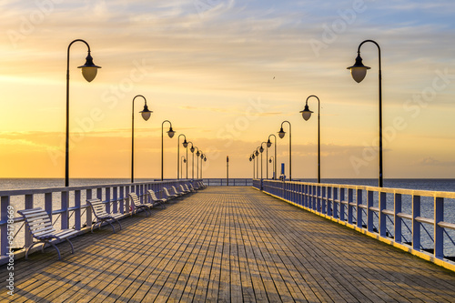 Naklejka dekoracyjna wooden pier by the sea lit by stylish lamps at night