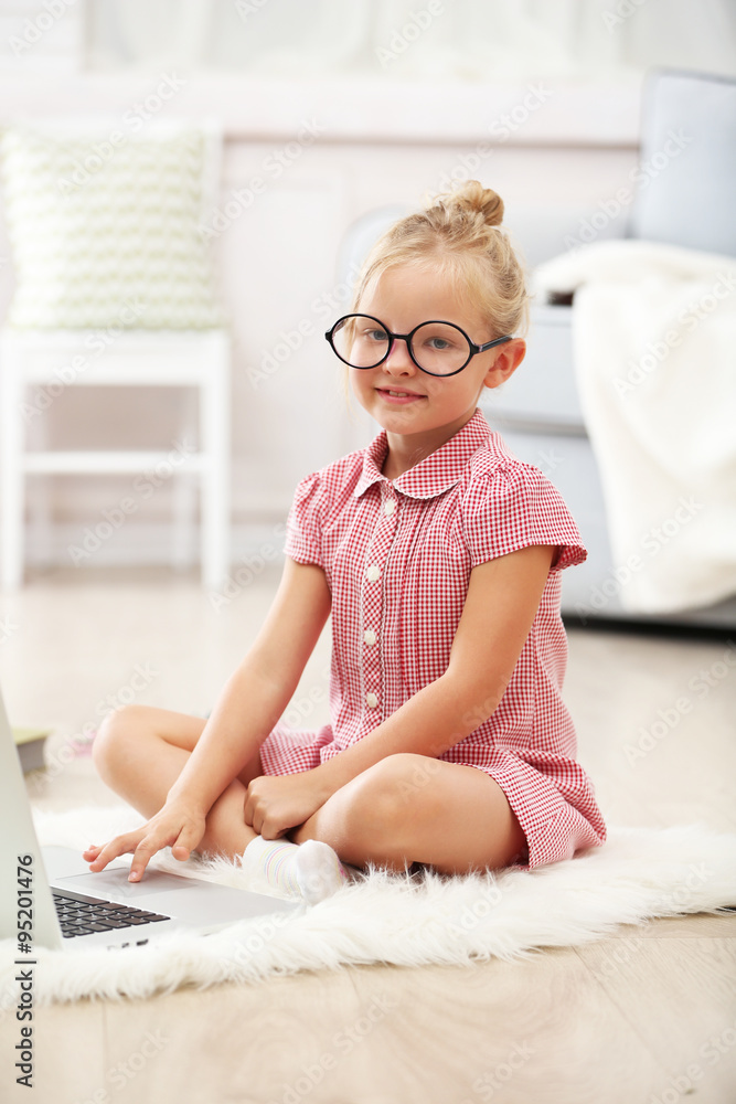 Little girl with laptop in the room