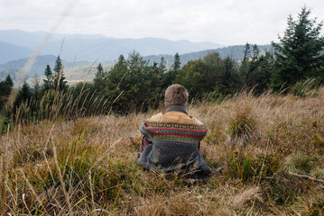 stylish beautiful traveling man hiking in the mountains on a bac