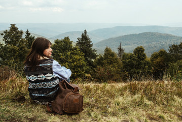 Canvas Print - beautiful happy stylish traveling girl sitting in the mountains