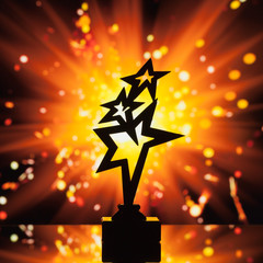 Wall Mural - gold stars trophy silhouette against shiny sparks background