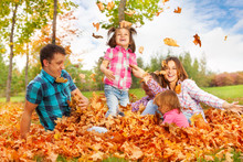 Mom And Girls Throw Leaves Up In The Air
