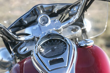 Motorcycle Chrome Speedometer And Odometer On A Red Fuel Tank, Outdoor In A Sunny Day