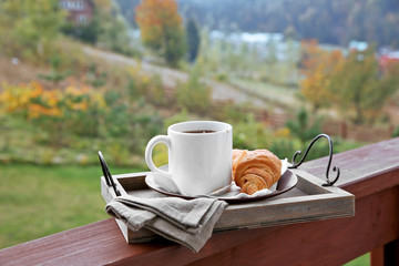 Wooden tray with light breakfast at terrace on mountains background