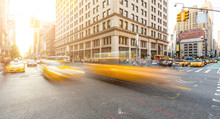 Busy Road Intersection In Manhattan, New York, At Sunset