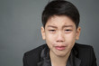 Little asian boy in black suit upset, depression face