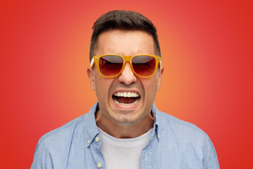 Poster - face of angry man in shirt and sunglasses over red