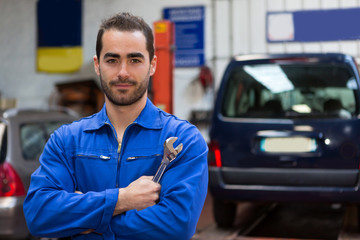 Wall Mural - Young attractive mechanic working at the garage