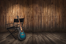 Guitar Near Chair On Wooden Wall Background