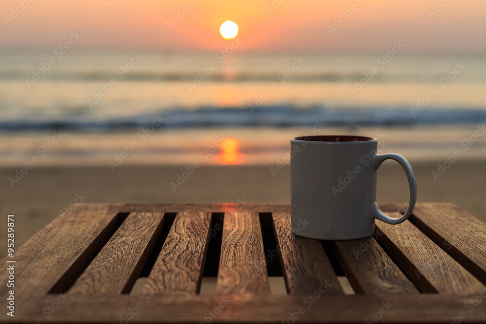 Coffee cup on wood table at sunset or sunrise beach Stock Photo | Adobe ...
