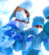 © lenetsnikolai - Team of surgeon in uniform perform operation on a patient at cardiac surgery clinic